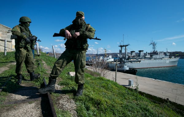 FILE - Russian soldiers guard a pier where two Ukrainian naval vessels are moored, in Sevastopol, on the Crimean Peninsula, March 5, 2014. (AP Photo, File)