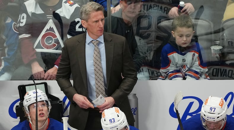 FILE - Edmonton Oilers head coach Kris Knoblauch looks on from behind the bench during the third period of an NHL hockey game, Tuesday, March 10, 2026, in Denver. (AP Photo/David Zalubowski, File)