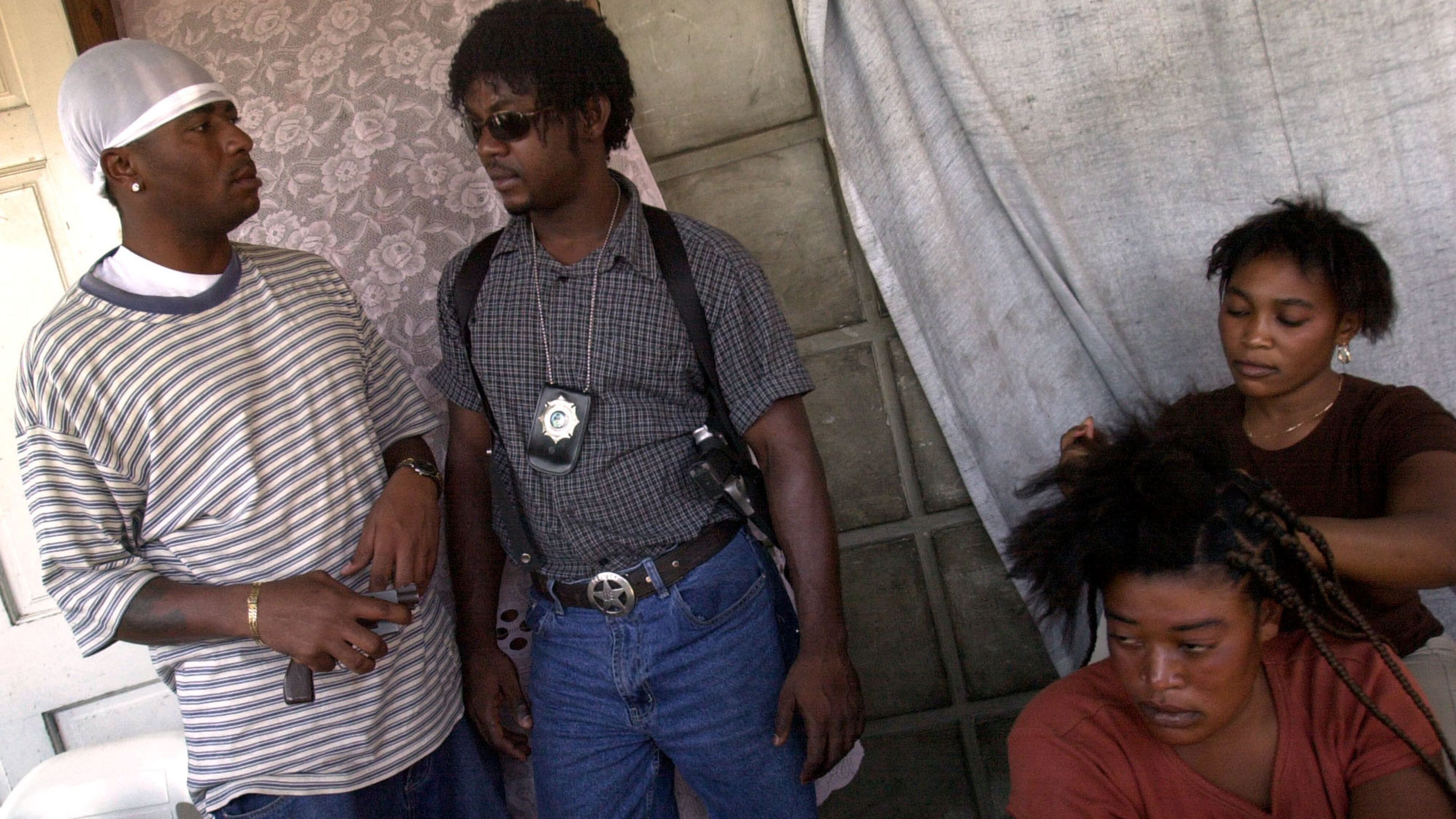 FILE - Wilfort Ferdinand, second left, talks with a member of his security team in Gonaives, March 6, 2004. (AP Photo/Walter Astrada, File)