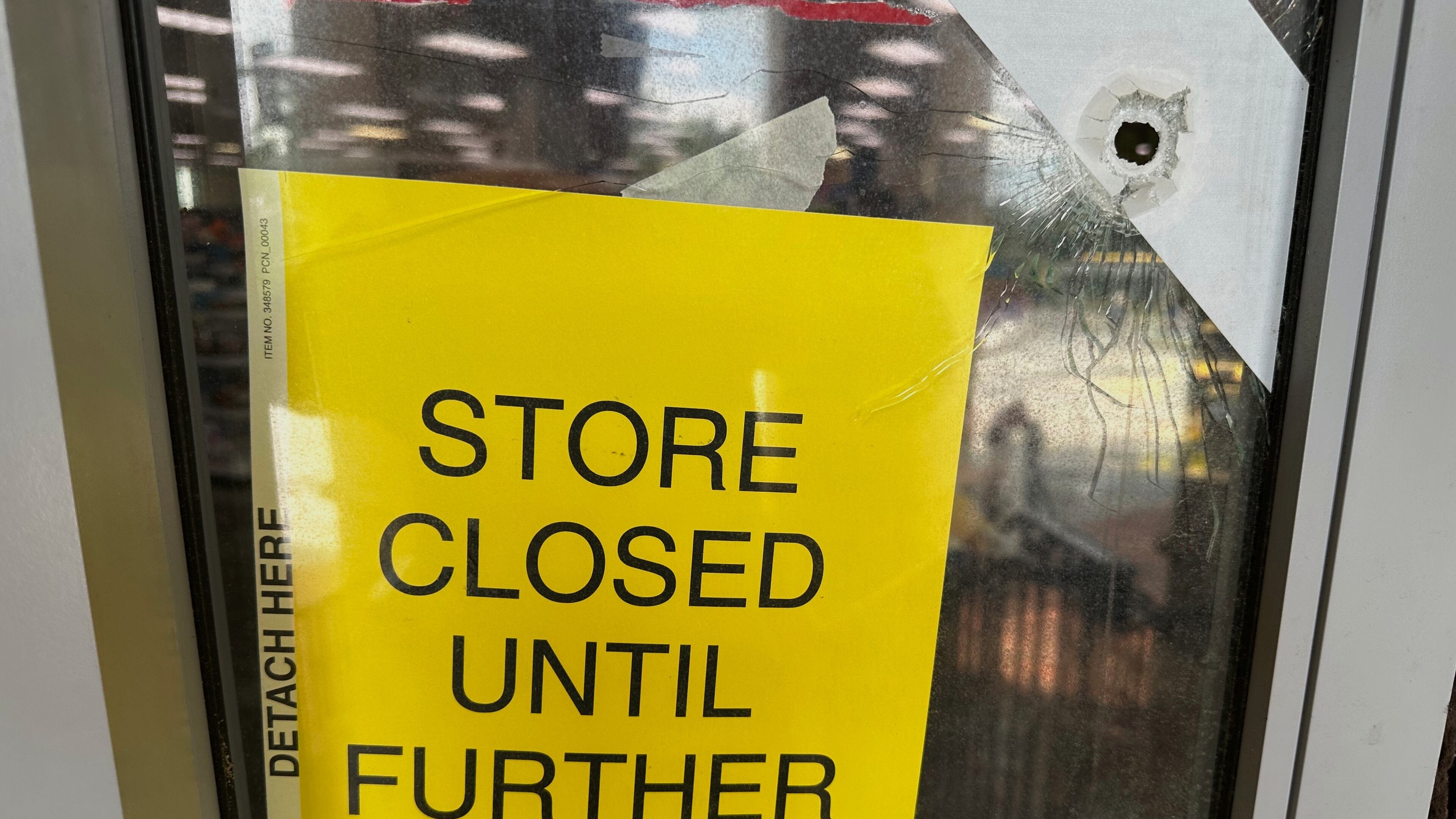 A bullet hole is visible in the door of a CVS pharmacy on Saturday, August 9, 2025, near where police say a man was shooting at the headquarters of the U.S. Centers for Disease Control and Prevention in Atlanta (AP Photo/Jeff Amy)