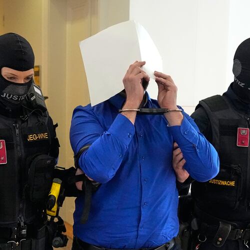 Defendant Beran A. is hiding his face behind file folders when he is escorted out of the courtroom in the District Court in Wiener Neustadt, Austria, where he stands trial for plotting to carry out an attack on one of superstar singer Taylor Swift's concerts in Vienna in August 2024 and pledging allegiance to the Islamic State group, Tuesday, April 28, 2026. (AP Photo/Matthias Schrader)