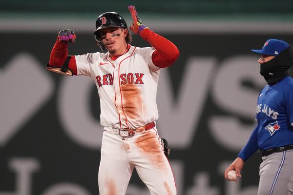Boston Red Sox's Jarren Duran, left, celebrates after his double during third inning of a baseball game against the Toronto Blue Jays, Monday, April 7, 2025, in Boston. (AP Photo/Charles Krupa)