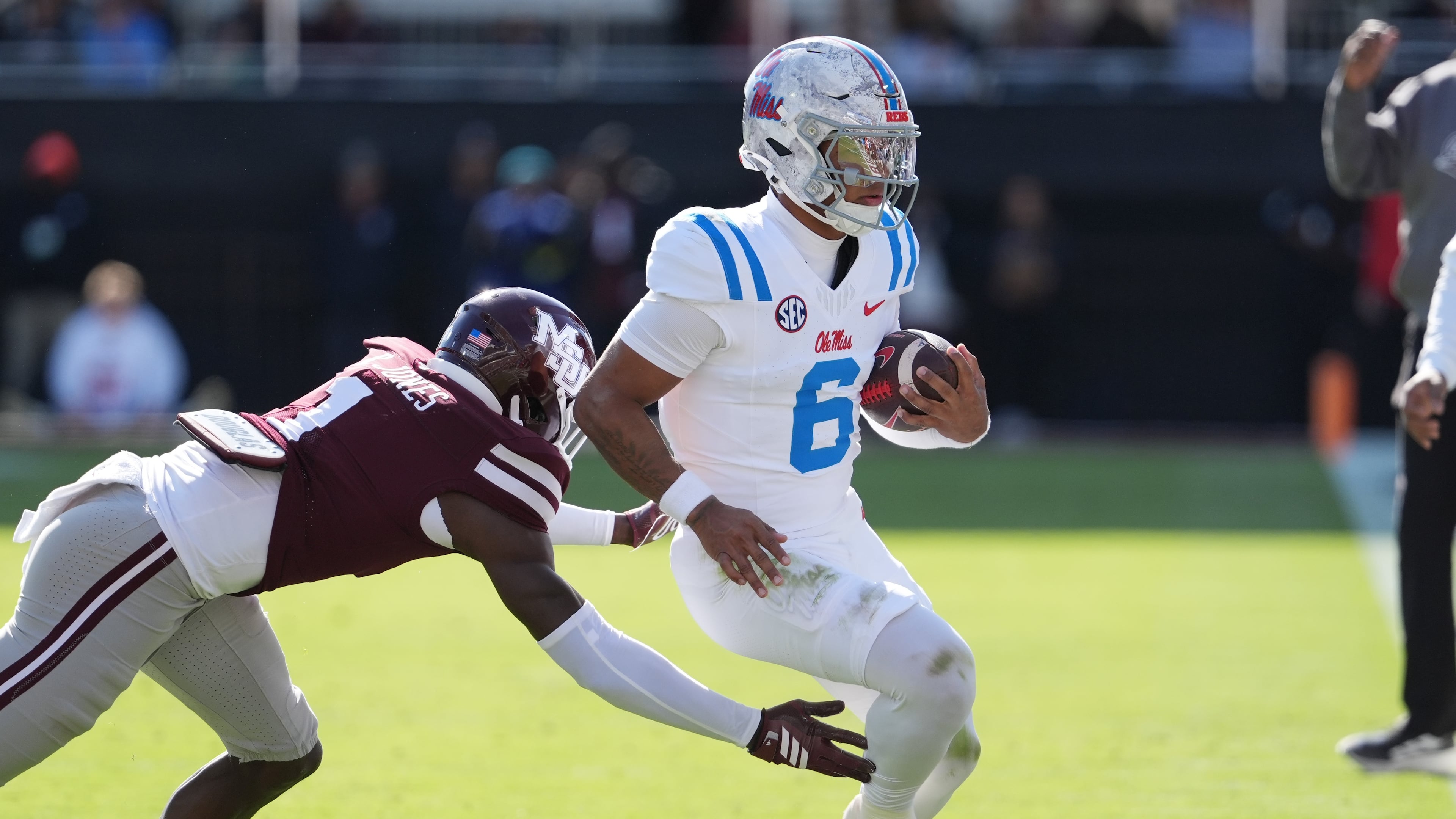 Mississippi quarterback Trinidad Chambliss (6) is pushed out-of-bounds by Mississippi State cornerback Kelley Jones (1) during the first half of an NCAA college football game Frifday, Nov. 28, 2025, in Starkville, Miss. (AP Photo/Rogelio V. Solis)