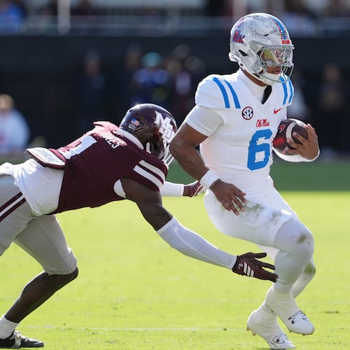 Mississippi quarterback Trinidad Chambliss (6) is pushed out-of-bounds by Mississippi State cornerback Kelley Jones (1) during the first half of an NCAA college football game Frifday, Nov. 28, 2025, in Starkville, Miss. (AP Photo/Rogelio V. Solis)