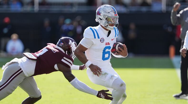 Mississippi quarterback Trinidad Chambliss (6) is pushed out-of-bounds by Mississippi State cornerback Kelley Jones (1) during the first half of an NCAA college football game Frifday, Nov. 28, 2025, in Starkville, Miss. (AP Photo/Rogelio V. Solis)