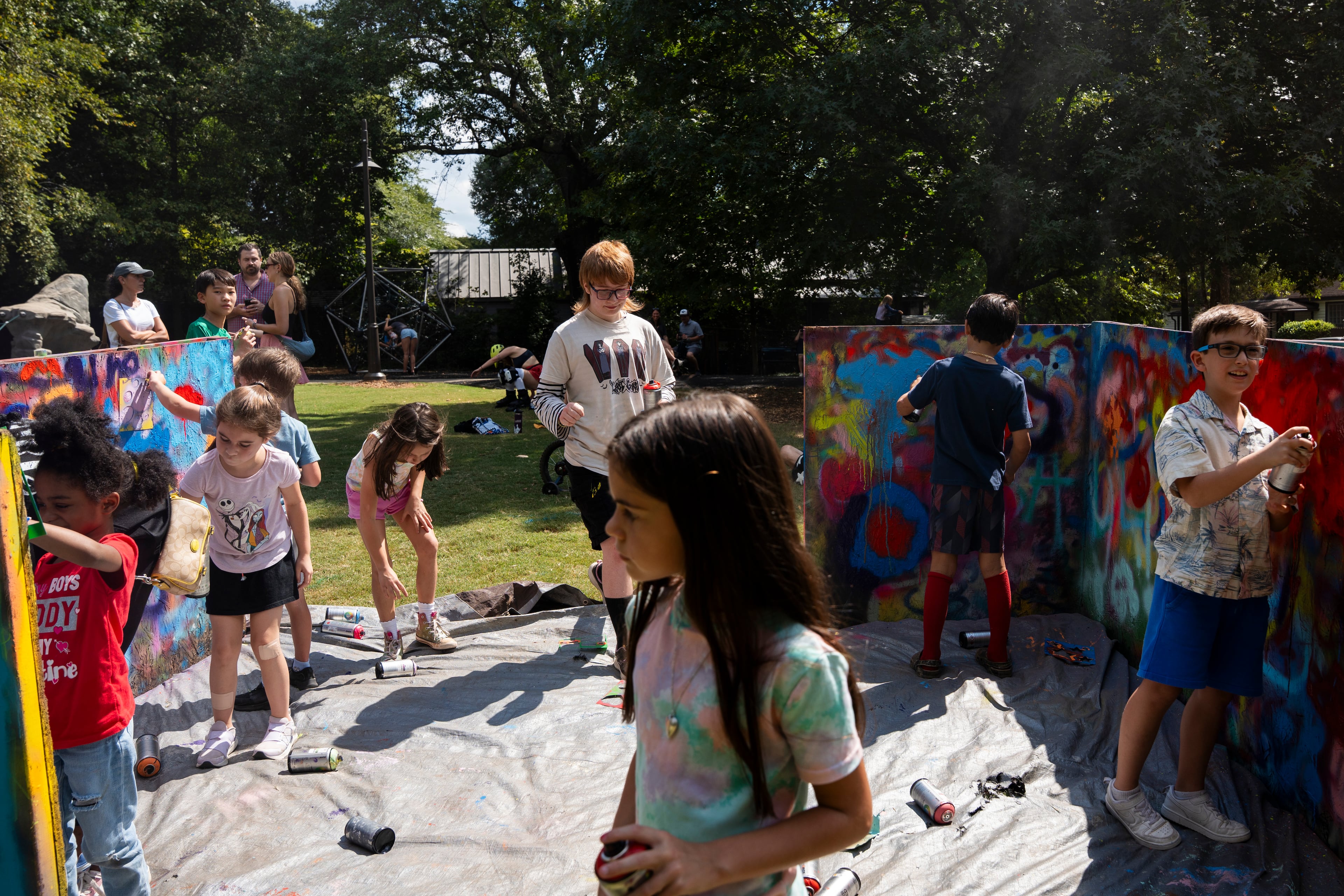 Kids paint with spray paint at the 11th annual Forward Warrior festival in the Cabbagetown neighborhood of Atlanta on Saturday, Sept. 13, 2025. (Olivia Bowdoin for the AJC)