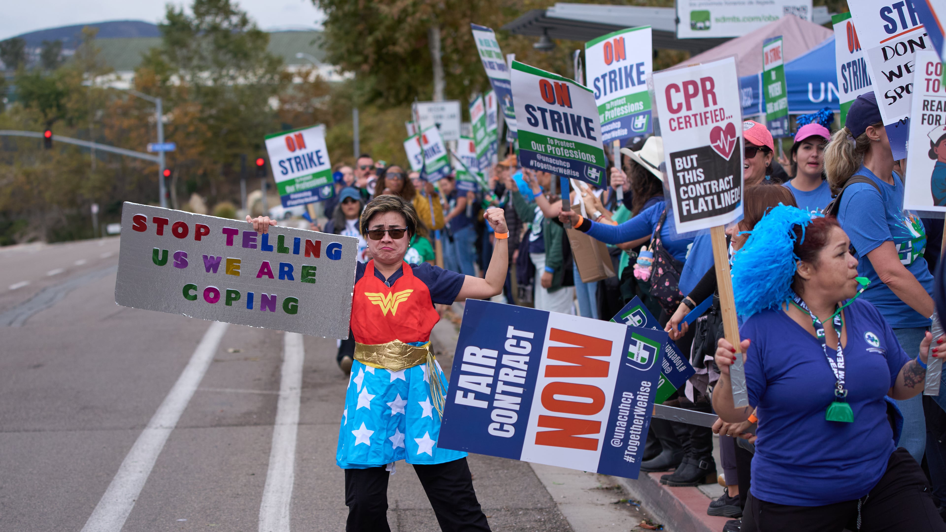 Kaiser Permanente health care workers hold signs and chant slogans while on strike in front of the Kaiser Permanente San Diego Medical Center Tuesday, Oct. 14, 2025, in San Diego. (AP Photo/Gregory Bull)
