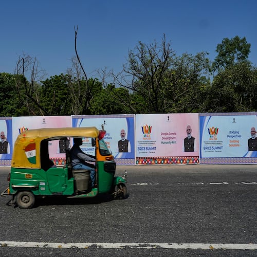 A three-wheeler drives past BRICS summit banners bearing an image of Indian Prime Minister Narendra Modi in New Delhi, India, Thursday, Sept. 10, 2026. (AP Photo/Manish Swarup)