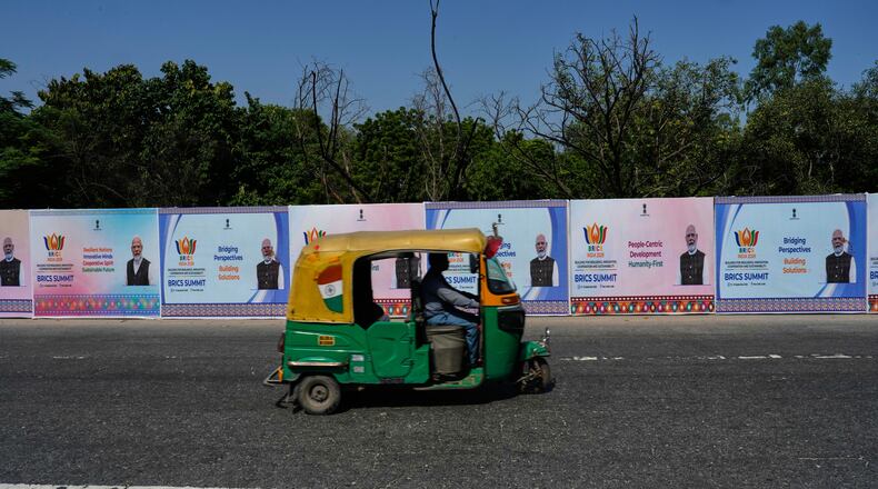 A three-wheeler drives past BRICS summit banners bearing an image of Indian Prime Minister Narendra Modi in New Delhi, India, Thursday, Sept. 10, 2026. (AP Photo/Manish Swarup)