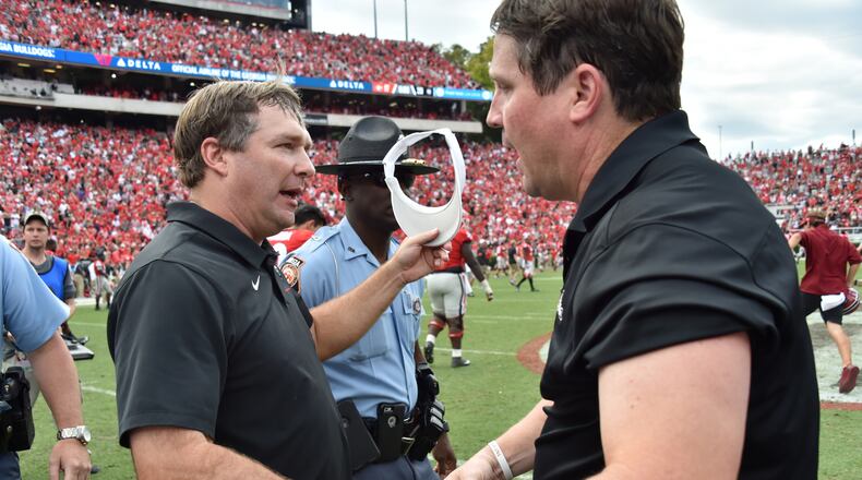Georgia coach Kirby Smart (left) and South Carolina coach Will Muschamp shake hands after South Carolina defeat the Georgia in double overtime during a NCAA college football game at Sanford Stadium in Athens on Oct. 12. They were teammates at Georgia in the 1990s and coached together on Valdosta State's staff in 2000. (Hyosub Shin / Hyosub.Shin@ajc.com)
