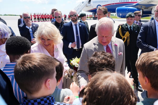 King Charles and Queen Camilla greet school children as they arrive at the Ottawa International Airport in Ottawa, Canada, for a royal visit on Monday, May 26, 2025. (Sean Kilpatrick/The Canadian Press via AP)
