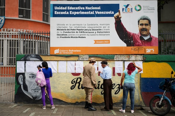 Voters look at the rolls at a polling station during legislative and local elections in Caracas, Venezuela, Sunday, May 25, 2025. (AP Photo/Ariana Cubillos)
