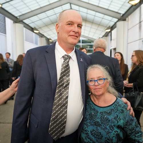 FILE - Michael Scott, left, hugs Sharon Shipman, the mother of yogurt shop suspect Forrest Welborn, after he was exonerated at a hearing for four men wrongfully accused in the 1991 Austin yogurt shop murders at the Blackwell-Thurman Criminal Justice Center in Austin, Texas, Feb. 19, 2026. (Jay Janner/Austin American-Statesman via AP, File)
