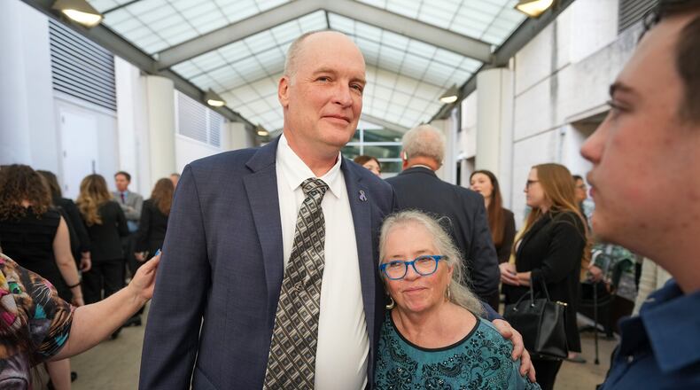 FILE - Michael Scott, left, hugs Sharon Shipman, the mother of yogurt shop suspect Forrest Welborn, after he was exonerated at a hearing for four men wrongfully accused in the 1991 Austin yogurt shop murders at the Blackwell-Thurman Criminal Justice Center in Austin, Texas, Feb. 19, 2026. (Jay Janner/Austin American-Statesman via AP, File)