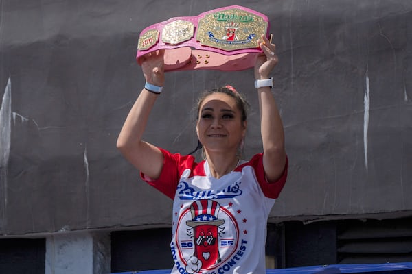 Competitive eater Miki Sudo raises a champion belt as she arrives at the 2025 Nathan's Famous Fourth of July hot dog eating contest in the Coney Island section of the Brooklyn borough of New York, Thursday, July 4, 2025. (AP Photo/Yuki Iwamura)