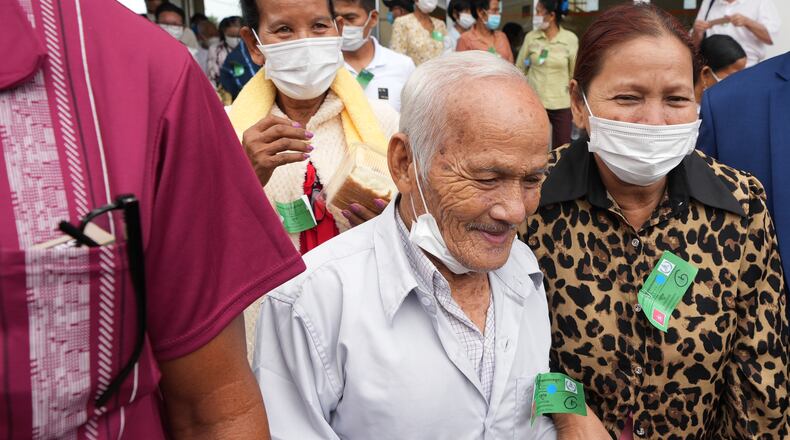 FILE- Bou Meng, center, former S-21 prison survivor, leaves the courtroom after the verdict is announced for Khieu Samphan, former Khmer Rouge head of state, at the U.N.-backed war crimes tribunal in Phnom Penh, Cambodia, Thursday, Sept. 22, 2022. (AP Photo/Heng Sinith, file)