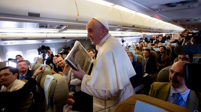 Pope Francis holds an image of Santa Teresa presented by a journalist as he leaves after his press conference on his flight from Sri Lanka to Manila, Philippines, Thursday, Jan. 15, 2015. (AP Photo/Alessandra Tarantino, Pool) Pope Francis made his comments aboard a plane flying to the Philippines. (AP Photo)