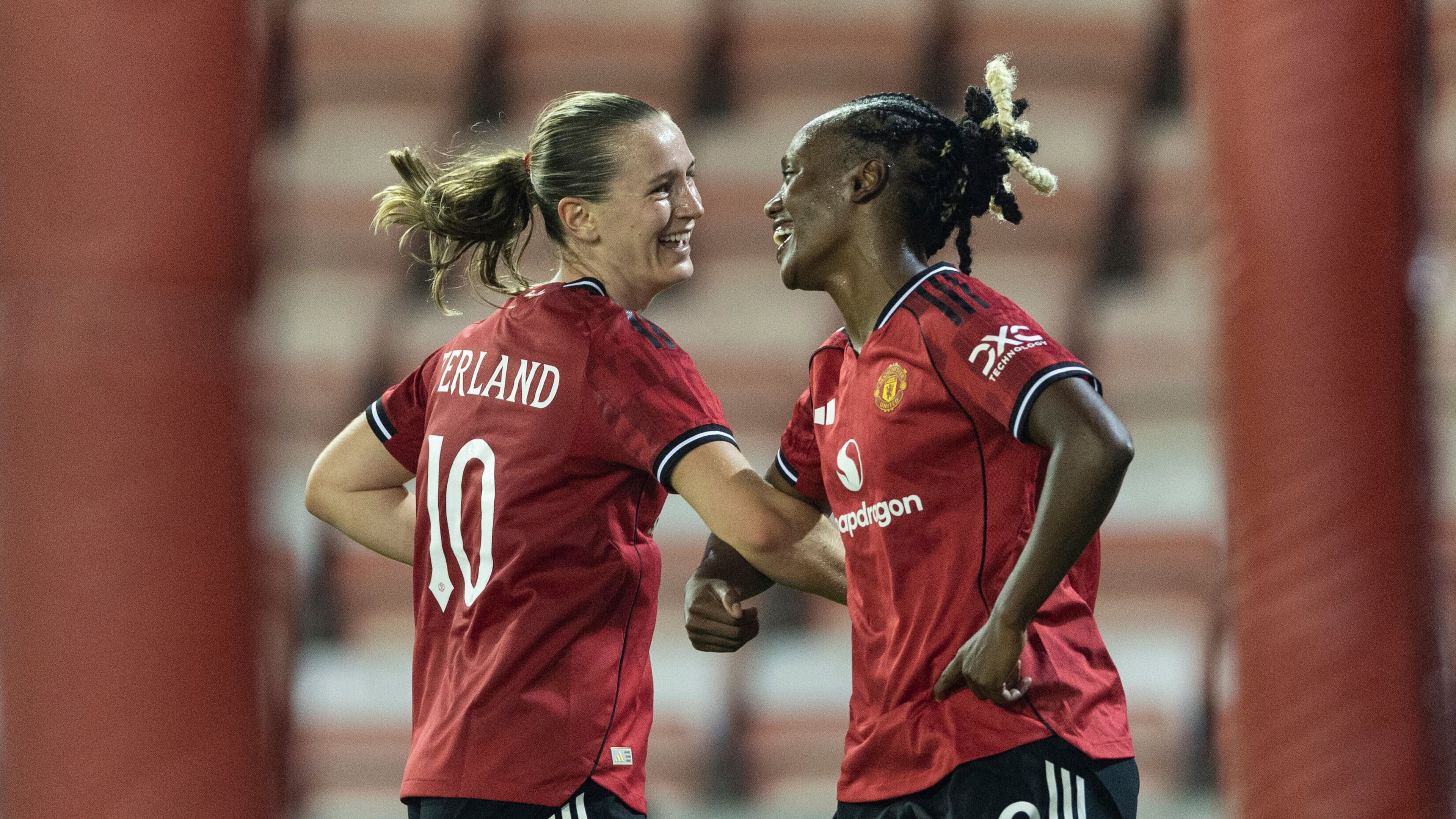 Manchester United's scorer Elisabeth Terland, left, and her teammate Melvine Malard, right, celebrate their side's third goal during the women's Champions League third qualifying round, second leg, soccer match between Manchester United and Brann in Leigh, England, Thursday, Sept. 18, 2025. (Barrington Coombs/PA via AP)