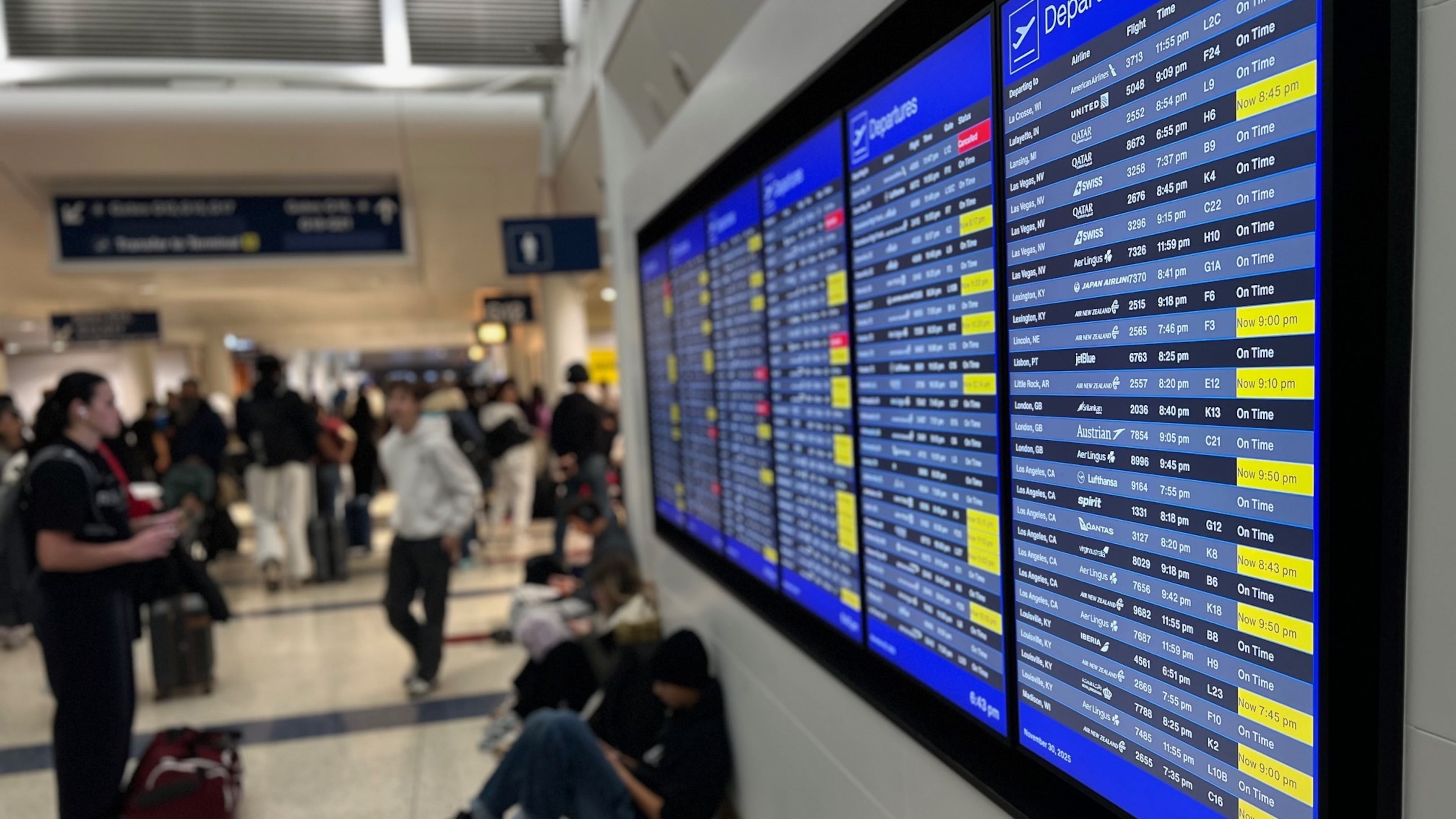 A departure board lists delayed and cancelled flights at O'Hare International Airport, Sunday, Nov. 30, 2025, in Chicago. (AP Photo/Adam Schreck)