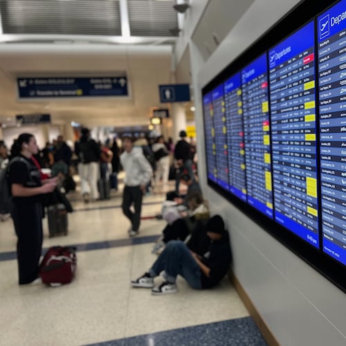 A departure board lists delayed and cancelled flights at O'Hare International Airport, Sunday, Nov. 30, 2025, in Chicago. (AP Photo/Adam Schreck)