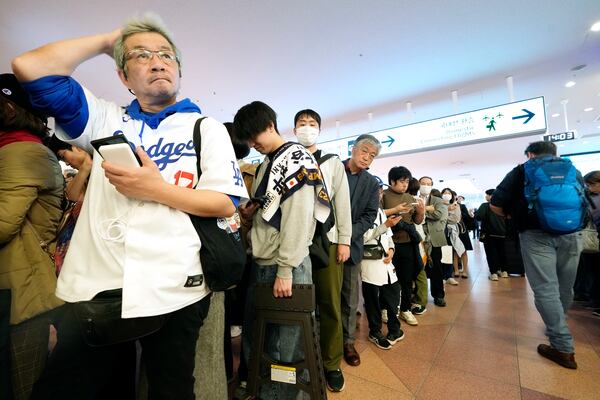 Fans of Los Angeles Dodgers wait for the team arrival at Tokyo International Airport Thursday, March 13, 2025, in Tokyo, as Los Angeles Dodgers is scheduled to play their MLB opening games against Chicago Cubs in Tokyo on March 18-19. (AP Photo/Hiro Komae)
