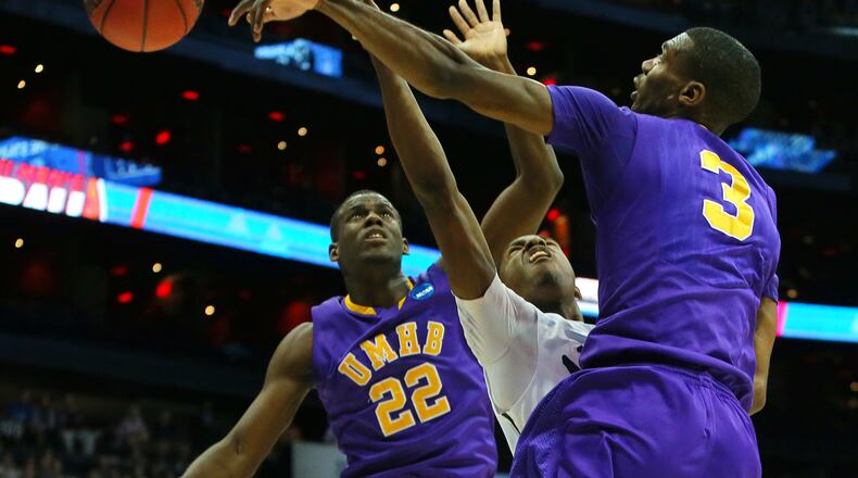 Mary Hardin-Baylor's Thomas Orr (right) blocks a shot by Amherst's David Kalema with help on defense from Kitrick Bell (left) during the first half in the NCAA Division III National Championship on Sunday, April 7, 2013, in Atlanta.