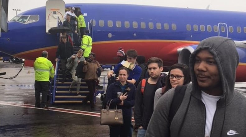 Passengers disembark from Southwest Airlines Flight 3392 from New Orleans. The plane landed at 1:30 p.m. Sunday, at Hartsfield-Jackson International Airport, but passengers sat on the plane for more than two hours because of the power outage just before their arrival. (Photo by Rick Crotts / AJC)