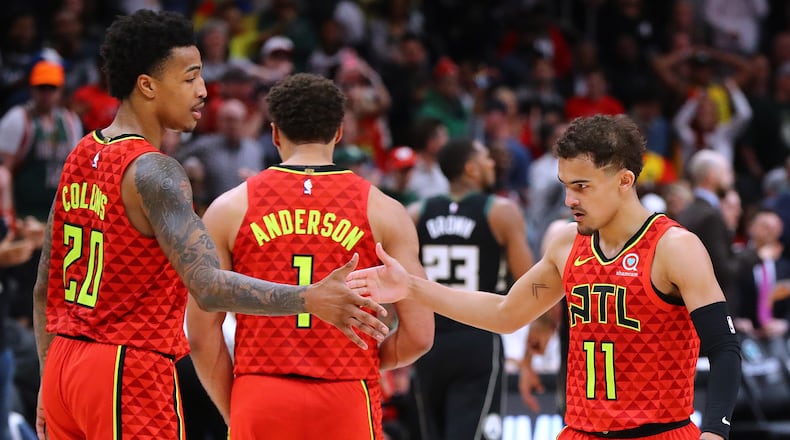 Atlanta Hawks guard Trae Young gets five from John Collins after hitting a shot during overtime against the Milwaukee Bucks on the way to a 136-135 victory in a NBA basketball game on Sunday, March 31, 2019, in Atlanta.    Curtis Compton/ccompton@ajc.com