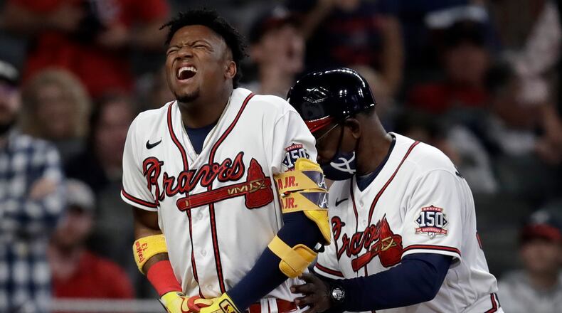Atlanta Braves' Ronald Acuna Jr., left, is assisted by third base coach Ron Washington after being hit by a pitch thrown by Philadelphia Phillies' Sam Coonrod in the seventh inning of a baseball game Saturday, May 8, 2021, in Atlanta. (AP Photo/Ben Margot)