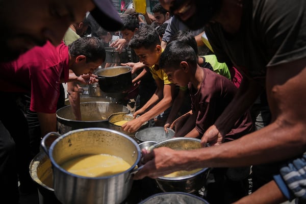 Palestinians receive donated food at a community kitchen in Gaza City, Tuesday, June 10, 2025. (AP Photo/Jehad Alshrafi)