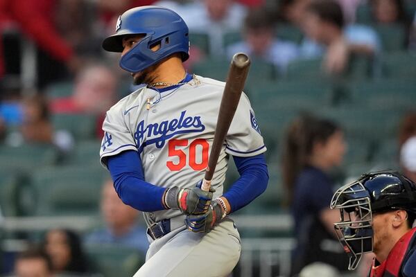 Los Angeles Dodgers shortstop Mookie Betts (50) hits a single against the Atlanta Braves in the fourth inning of a baseball game, Friday, May 2, 2025, in Atlanta. (AP Photo/Mike Stewart)