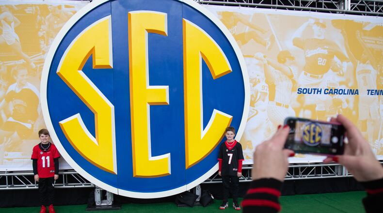 Anna Gibbs takes a photograph of her two sons Bo (L) and Blake by a giant SEC sign during the Dr. Pepper SEC FanFare at the Georgia World Congress Center on Dec. 7.