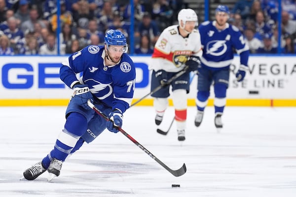 Tampa Bay Lightning center Anthony Cirelli (71) carries the puck ahead of Florida Panthers center Sam Reinhart (13) during the second period in Game 2 of an NHL hockey Stanley Cup first-round playoff series, Thursday, April 24, 2025, in Tampa, Fla. (AP Photo/Chris O'Meara)
