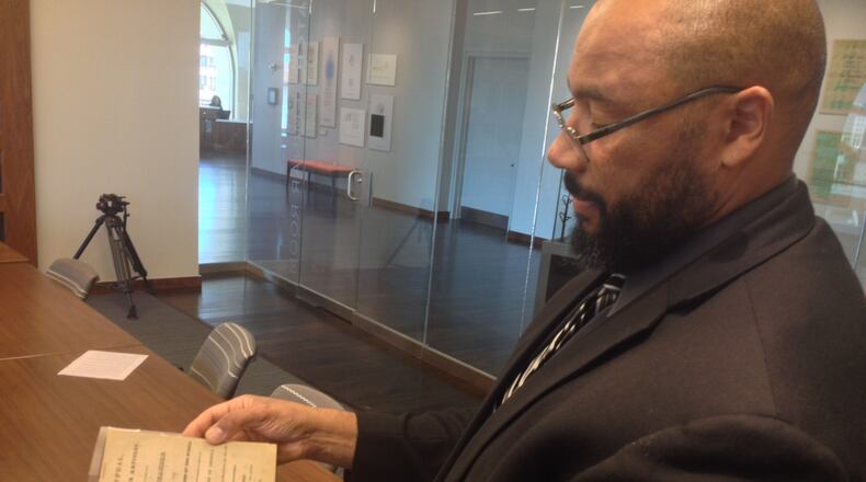 Pellom McDaniels III, a faculty curator of the African American Collections at Emory, marvels at a rare copy of “David Walker’s Appeal” in this AJC file photo. McDaniels died Sunday, April 19, 2020. He was 52.