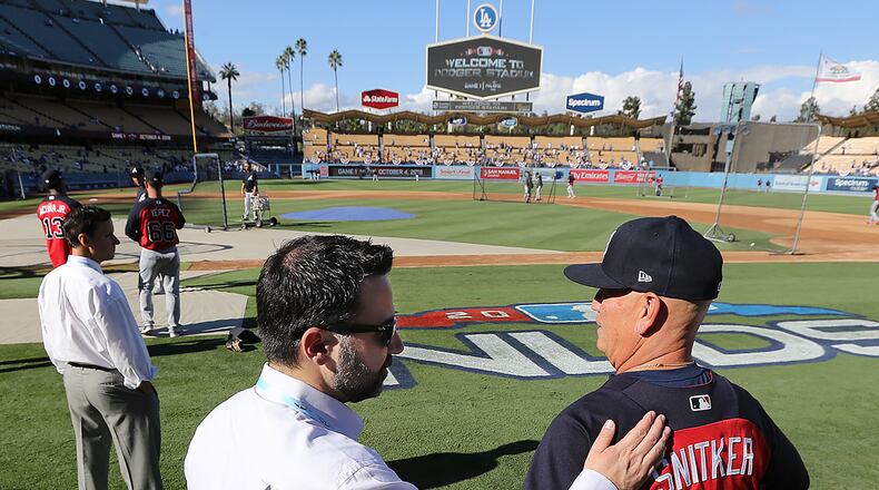 Atlanta Braves general manager Alex Anthopoulos gives manager Brian Snitker a pat on the back before Game 1 of the National League Division Series on Thursday, Oct 4, 2018, in Los Angeles.