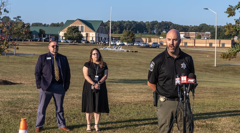 Barrow County Sheriff Jud Smith (right) speaks as Barrow County Schools Chief of Staff Matt Thompson (left) and Director of Communications and Engagement Nicole Valles (center) look on. Months after a student is accused of shooting and killing four people at Apalachee High School, the county is struggling to hire new school resource officers. (John Spink/AJC 2024)
