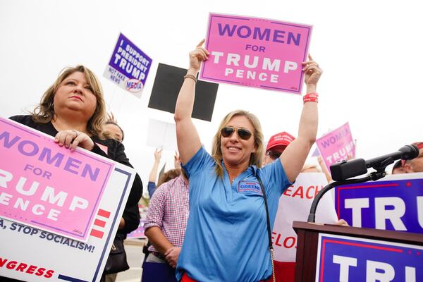 Republican Marjorie Taylor Greene, center, participates in a “Stop Impeachment Now” rally outside the Sandy Springs office of Democratic U.S. Rep. Lucy McBath in October, when Greene was a candidate in the 6th Congressional District that McBath represents. Greene later moved her campaign to the 14th Congressional District, where she won the GOP runoff on Tuesday. (Elijah Nouvelage for The Atlanta Journal-Constitution)