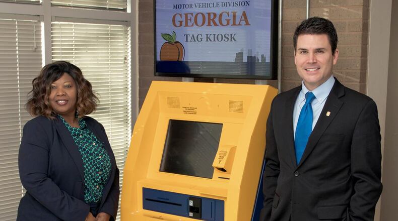 North Gwinnett tag office manager Elaine Melvin-Morgan, left, and Gwinnett Tax Commissioner Richard Steele pose with a new self-service kiosk. (AJC File Photo)