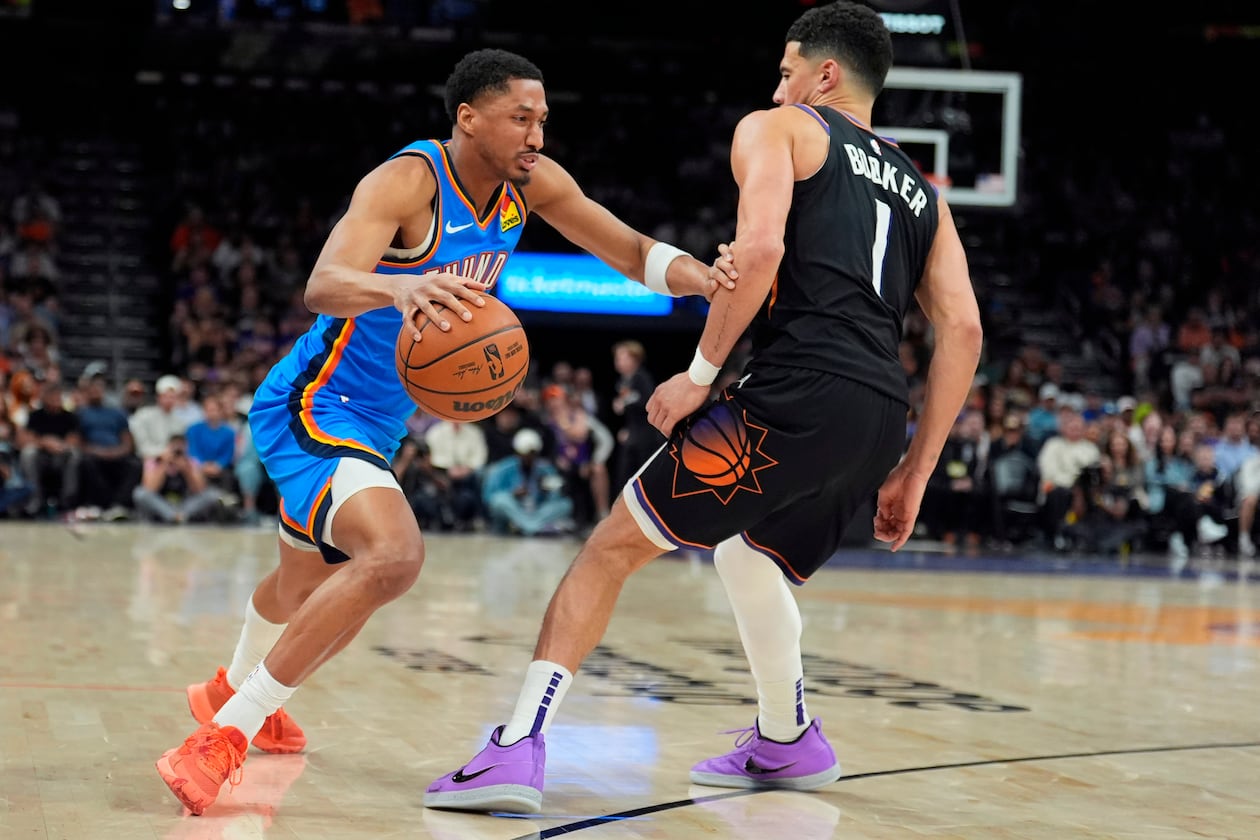 Oklahoma City Thunder guard Aaron Wiggins, left, dribbles the ball against Phoenix Suns guard Devin Booker (1) during the second half of Game 4 in a first-round NBA playoffs basketball series, Monday, April 27, 2026, in Phoenix. (AP Photo/Ross D. Franklin)