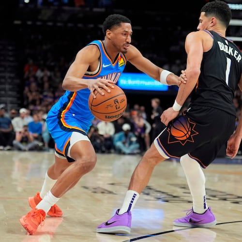 Oklahoma City Thunder guard Aaron Wiggins, left, dribbles the ball against Phoenix Suns guard Devin Booker (1) during the second half of Game 4 in a first-round NBA playoffs basketball series, Monday, April 27, 2026, in Phoenix. (AP Photo/Ross D. Franklin)
