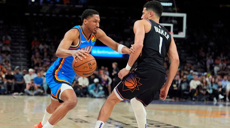 Oklahoma City Thunder guard Aaron Wiggins, left, dribbles the ball against Phoenix Suns guard Devin Booker (1) during the second half of Game 4 in a first-round NBA playoffs basketball series, Monday, April 27, 2026, in Phoenix. (AP Photo/Ross D. Franklin)