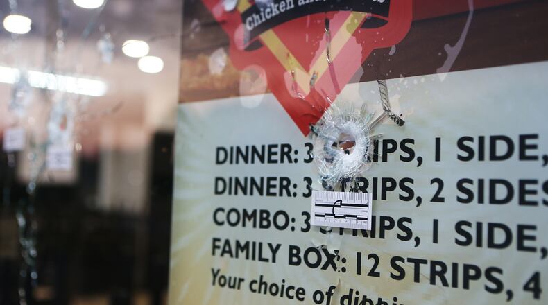 Bullets cracked the glass windows of the Mrs. Winner's on Glenwood Road on Friday, the morning after an armed robber fired several rounds inside the fast-food restaurant.
