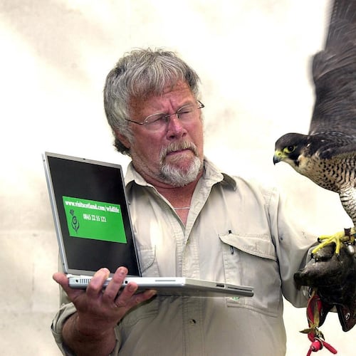 FILE - Bill Oddie launches the Visit Scotland new website (www.visitscotland.com/wildlife) with Tam the Peregrine falcon at Visitscotland's London office, May 6, 2004. (Michael Stephens/PA via AP, File)