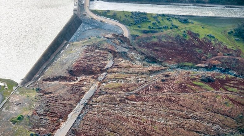 In an aerial photo, the emergency spillway at Lake Oroville shows signs of damage from the water which spilled over recently, on Monday, Feb. 13, 2017, in Oroville, Calif. Sunday afternoon's evacuation order came after engineers spotted a hole on the concrete lip of the secondary spillway for the 770-foot-tall Oroville Dam and told authorities that it could fail within the hour.  (Randy Pench/The Sacramento Bee via AP)