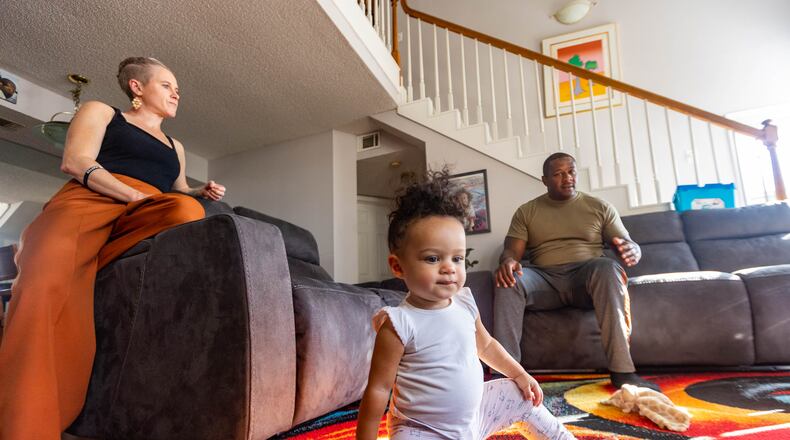 Akil Sanders, right, with his wife, Stefanie, and their daughter, Nola, in their Old Fourth Ward home. Not all Atlanta residents agree about how to tackle Atlanta's crime surge. But many like Sanders see the issue intertwined with joblessness, poverty, desperation amid the coronavirus pandemic and shortages in affordable housing. Targeting those problems, they said, would make an impact. 
 (Jenni Girtman for The Atlanta Journal-Constitution)