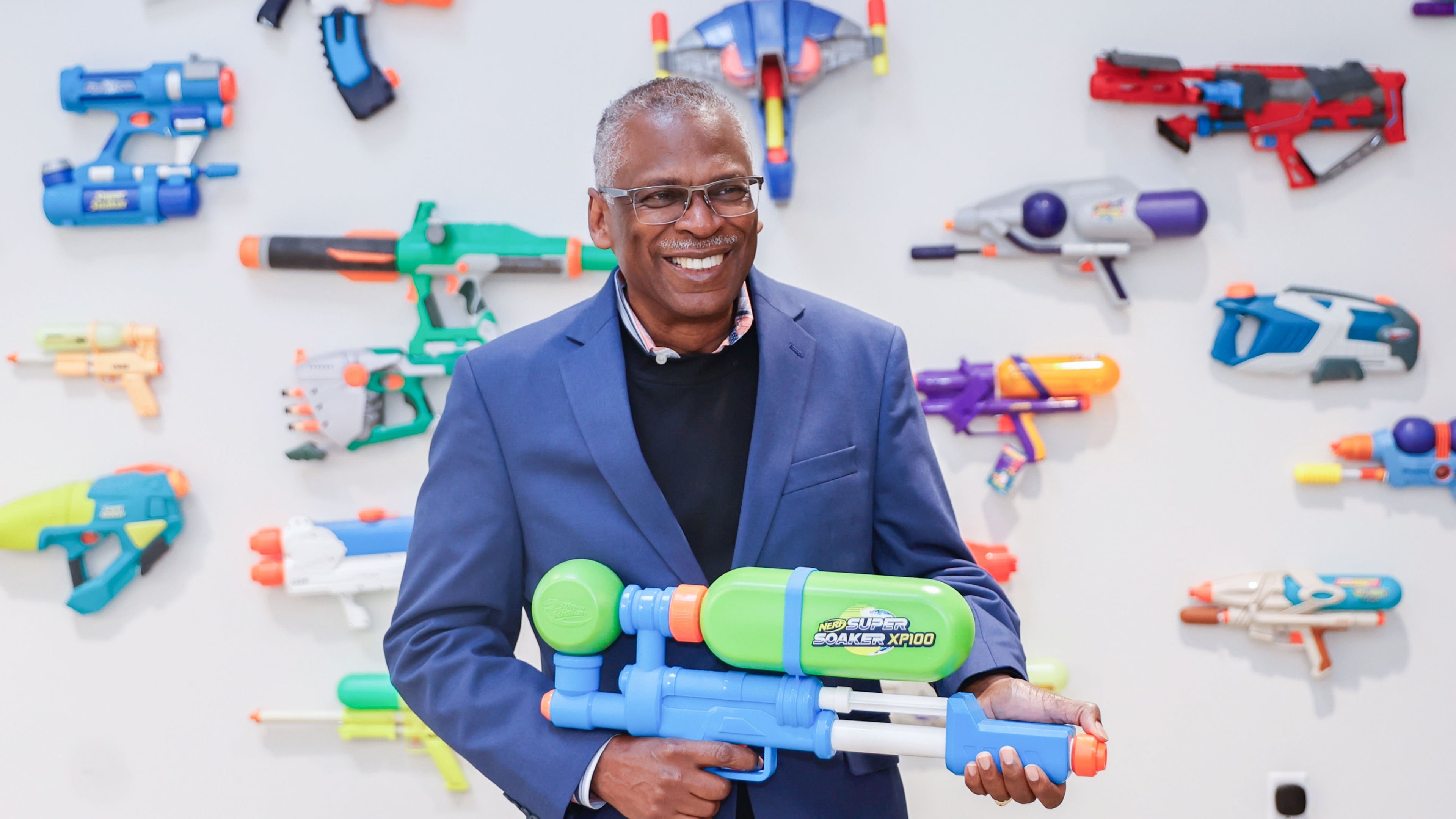 Inventor Lonnie Johnson poses in front of a display of his Super Soaker water guns at JTEC Energy in Atlanta.