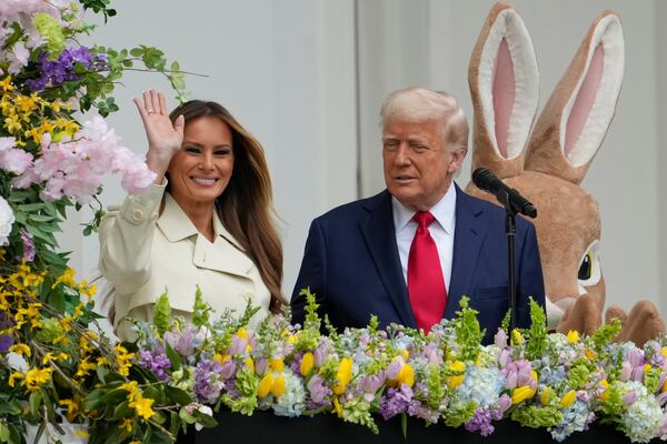 President Donald Trump watches as first lady Melania Trump waves from the Blue Room Balcony during the White House Easter Egg Roll on the South Lawn of the White House, Monday, April 21, 2025, in Washington. (AP Photo/Alex Brandon)