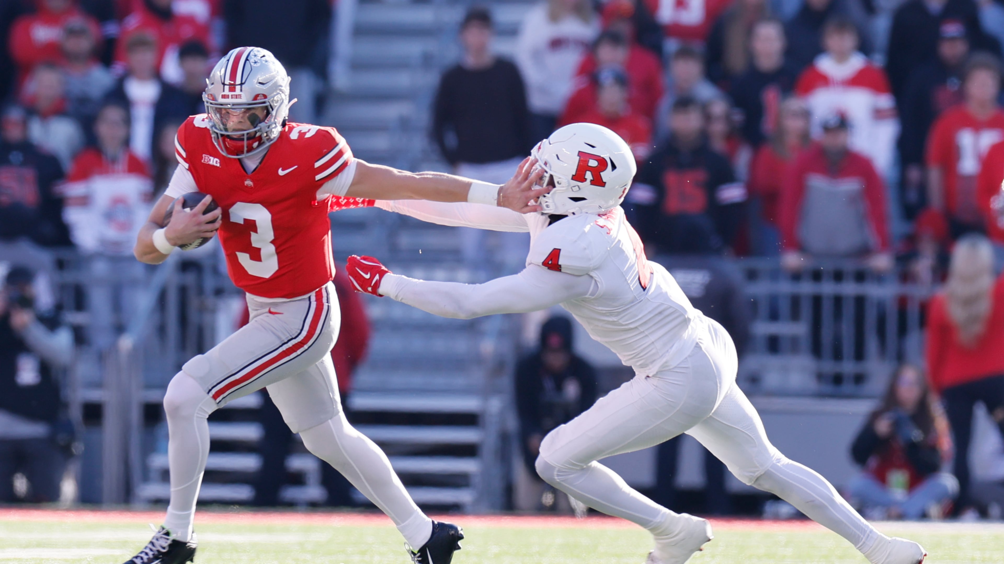 Ohio State quarterback Lincoln Kienholz, left, stiff arms Rutgers linebacker Sam Robinson during the second half of an NCAA college football game, Saturday, Nov. 22, 2025, in Columbus, Ohio. (AP Photo/Jay LaPrete)