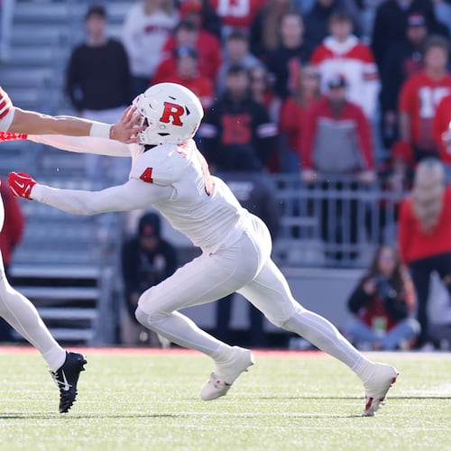 Ohio State quarterback Lincoln Kienholz, left, stiff arms Rutgers linebacker Sam Robinson during the second half of an NCAA college football game, Saturday, Nov. 22, 2025, in Columbus, Ohio. (AP Photo/Jay LaPrete)
