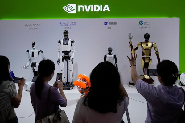 Visitors give commands to a robot at Nvidia's booth during the 3rd China International Supply Chain Expo at the China International Exhibition Center, in Beijing, China, Friday, July 18, 2025. (AP Photo/Mahesh Kumar A.)